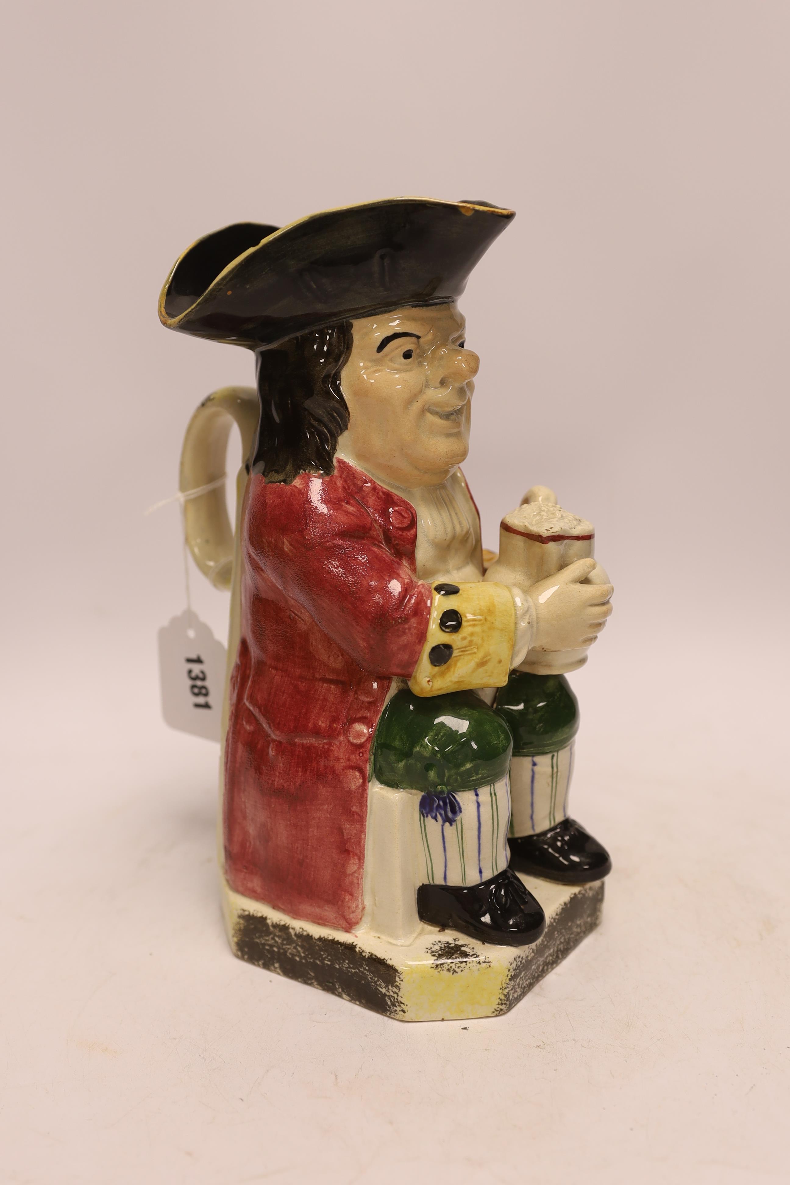 A Yorkshire Toby jug, c.1800, modelled holding a frothing jug, pink coat and green breeches, 26.5cm high. Condition - chips to rim of hat, possible restoration in places